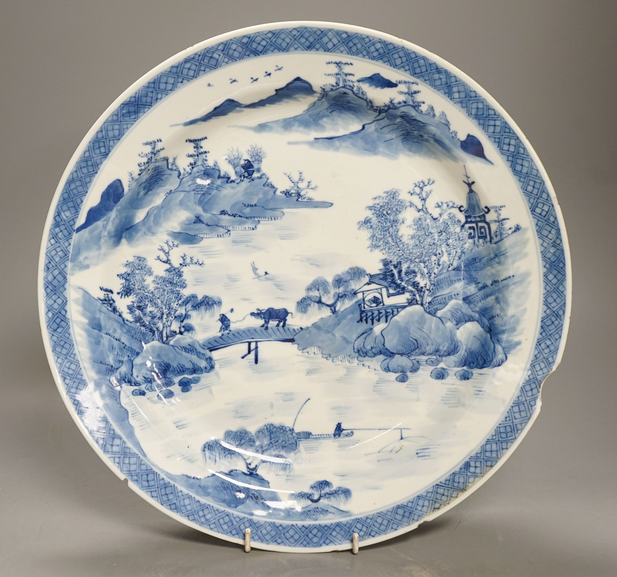 A Chinese blue and white landscape dish, Kangxi mark but 19th century, 36cm